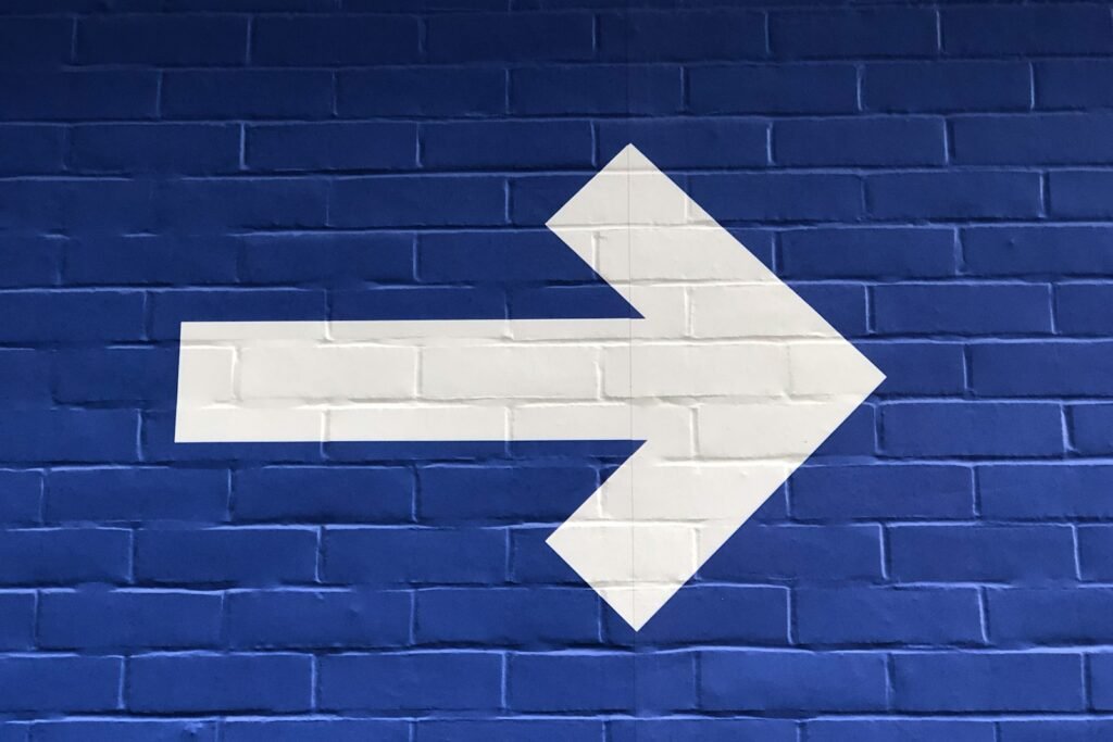 white arrow painted on brick wall signifying clarity and direction in cross functional leadership