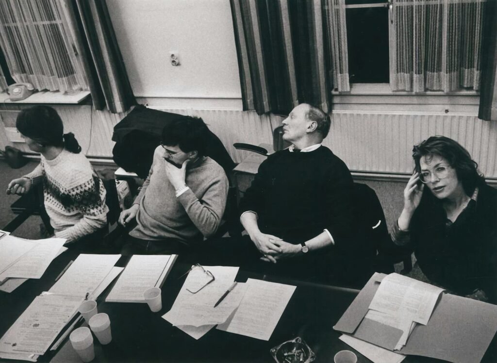 how much time your team wastes in meetings - bored professionals at a desk