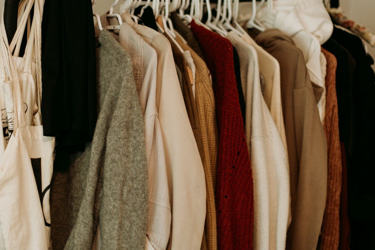Neatly hung coats on a rail, an organized closet as the first step in how to get organized at home